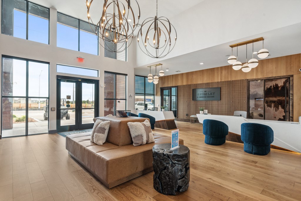 a living room with a couch and chairs and a large window