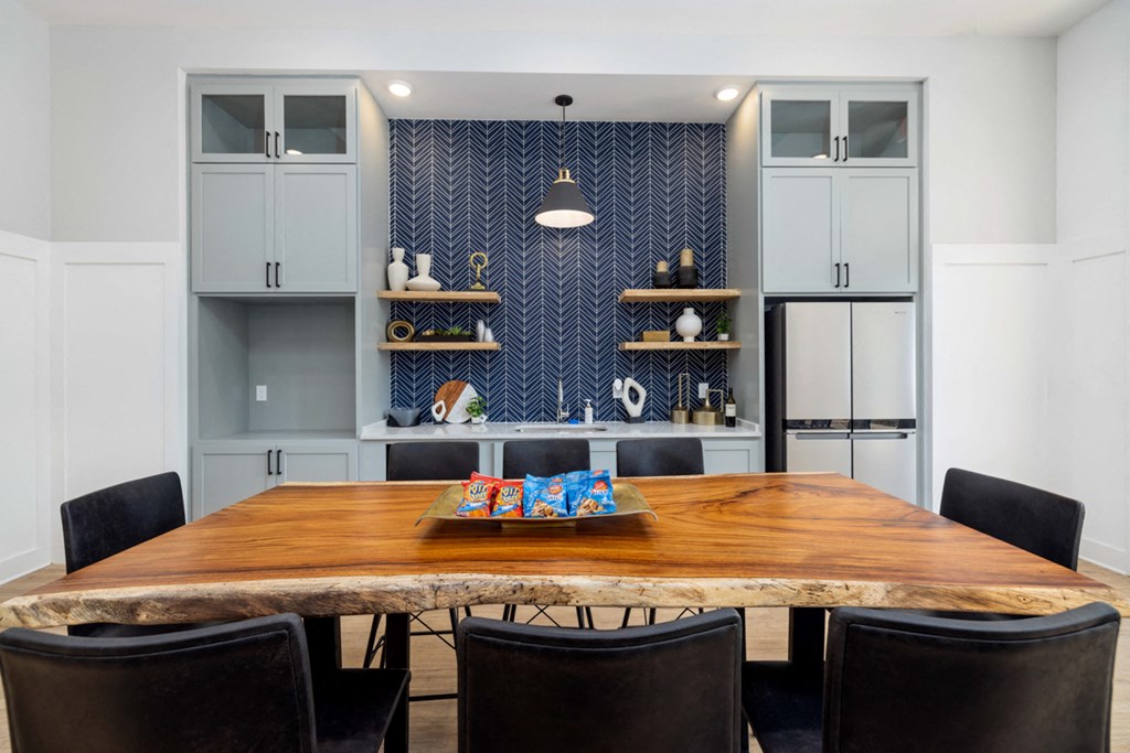 a kitchen with a wooden table and black chairs