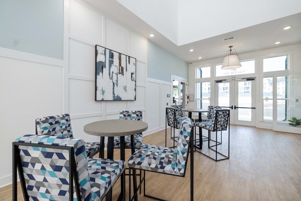 a living room with chairs and tables and a dining room table and chairs