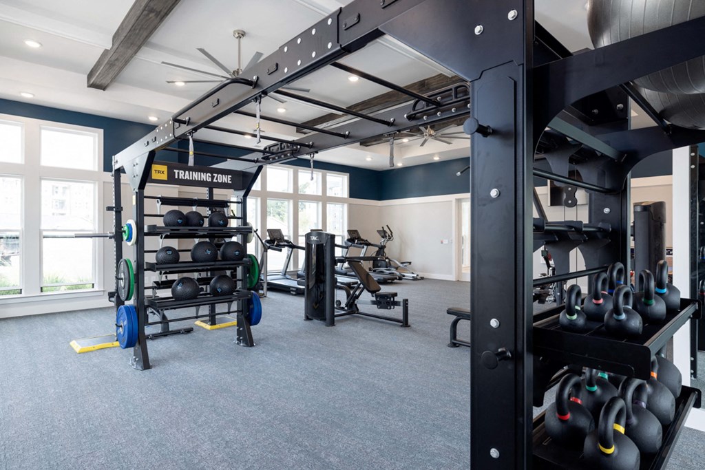 a gym with weights and other exercise equipment and windows