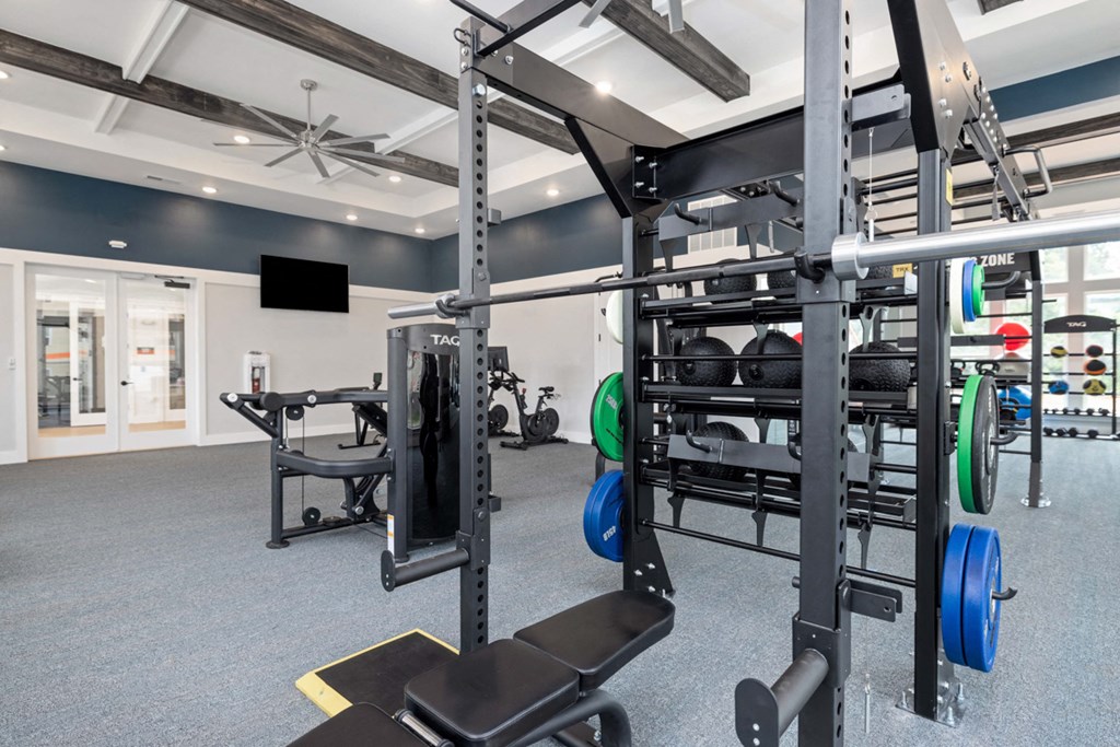 a gym with weights and other exercise equipment in a building with white walls