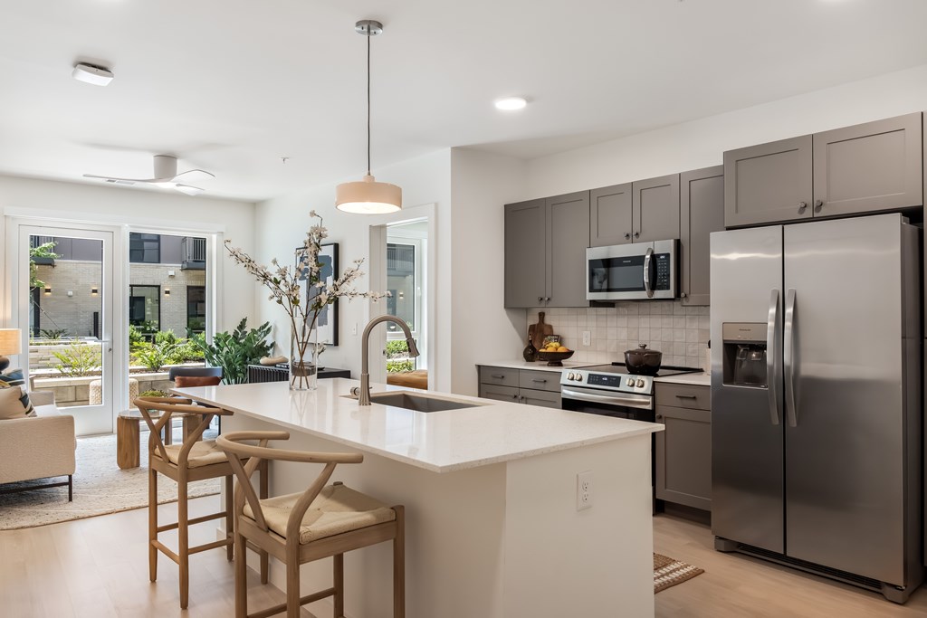 A modern kitchen with a large island and stainless steel appliances.