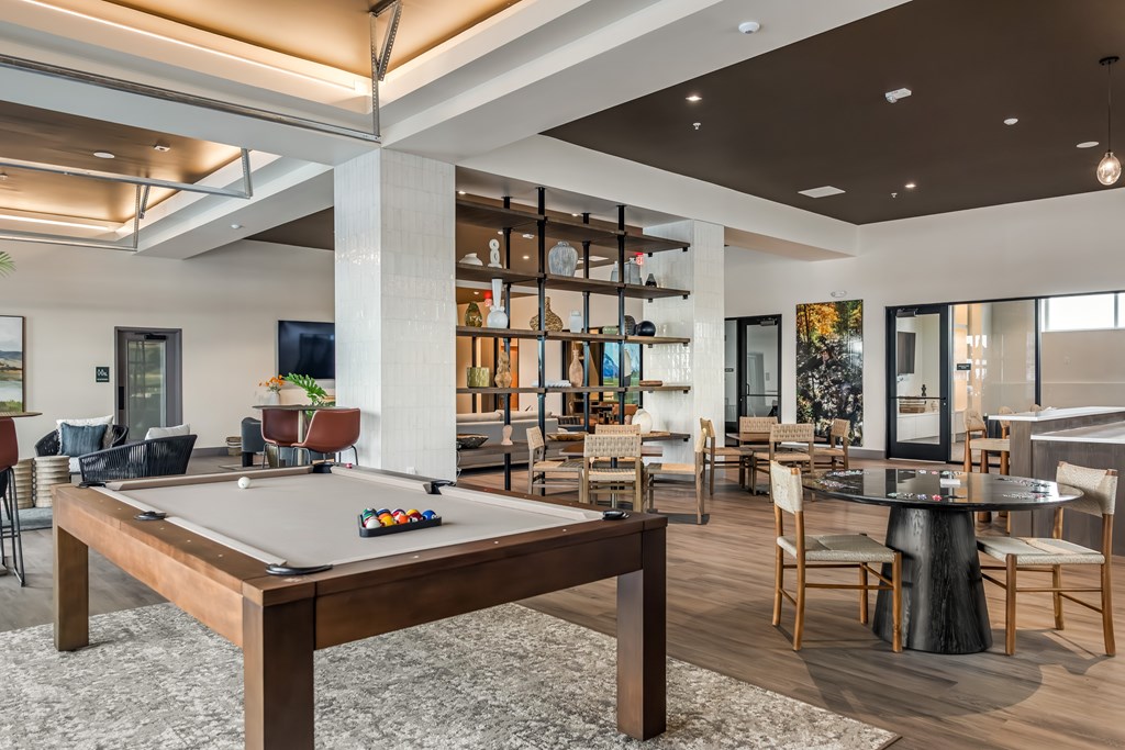 A billiard table is in the middle of a room with a pool table light.