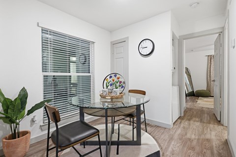 A dining room with a glass table and chairs.