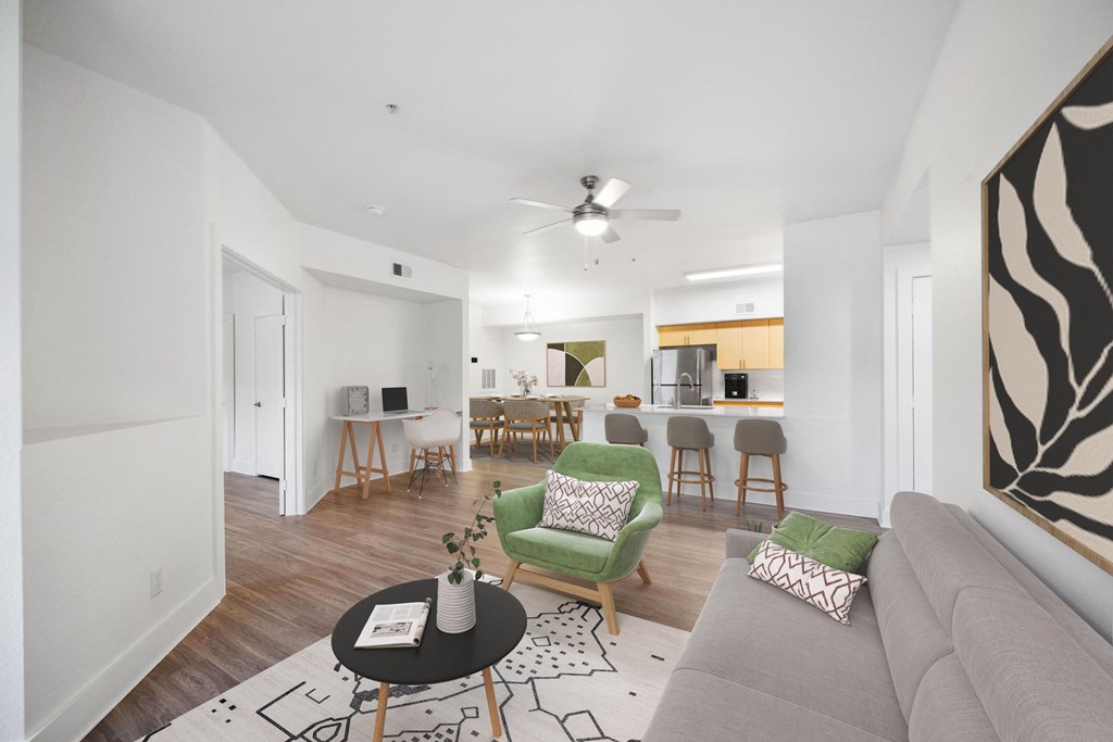 a living room with a couch and a chair and a kitchen with a dining area
