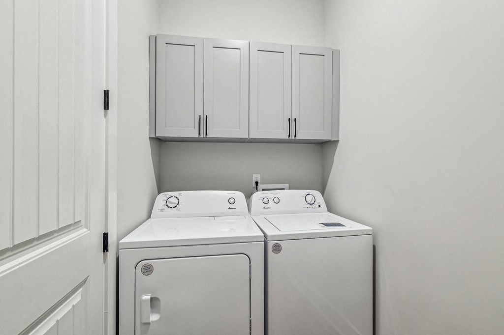 A white washing machine and dryer in a laundry room.