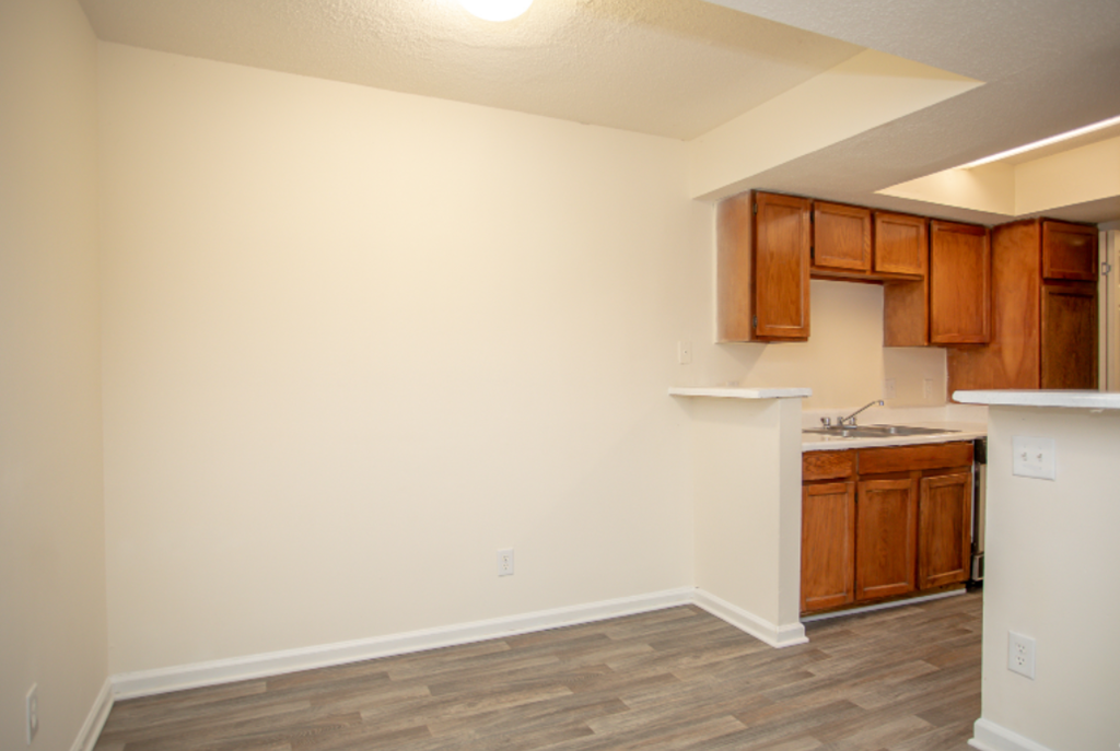 an empty kitchen with wood flooring and white walls