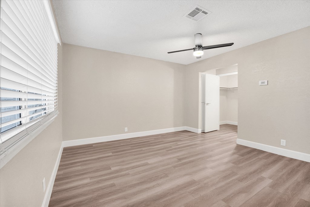 a bedroom with hardwood floors and a ceiling fan