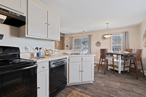 A kitchen with white cabinets and a black stove top oven.