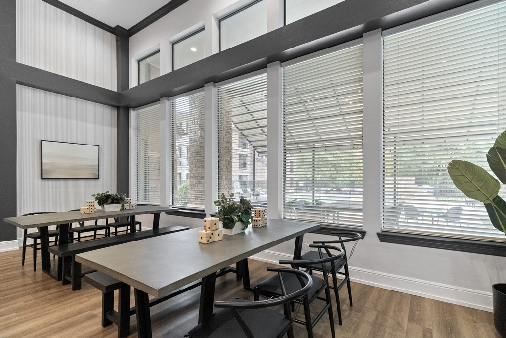 a dining room with large windows and a table with chairs