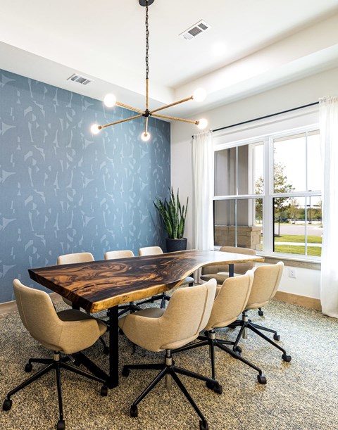 A wooden table with four chairs and a hanging light fixture.