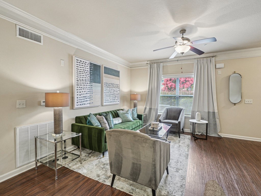 A living room with a green couch and a grey chair.