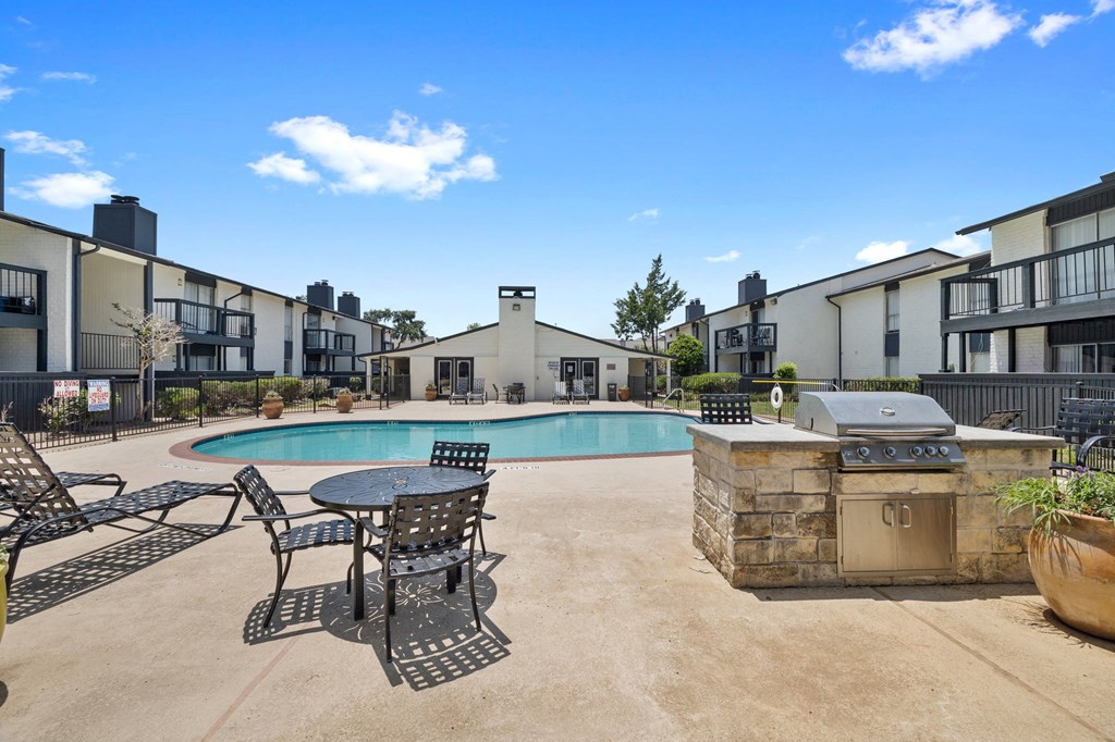 our apartments have a large pool and patio with chairs and tables