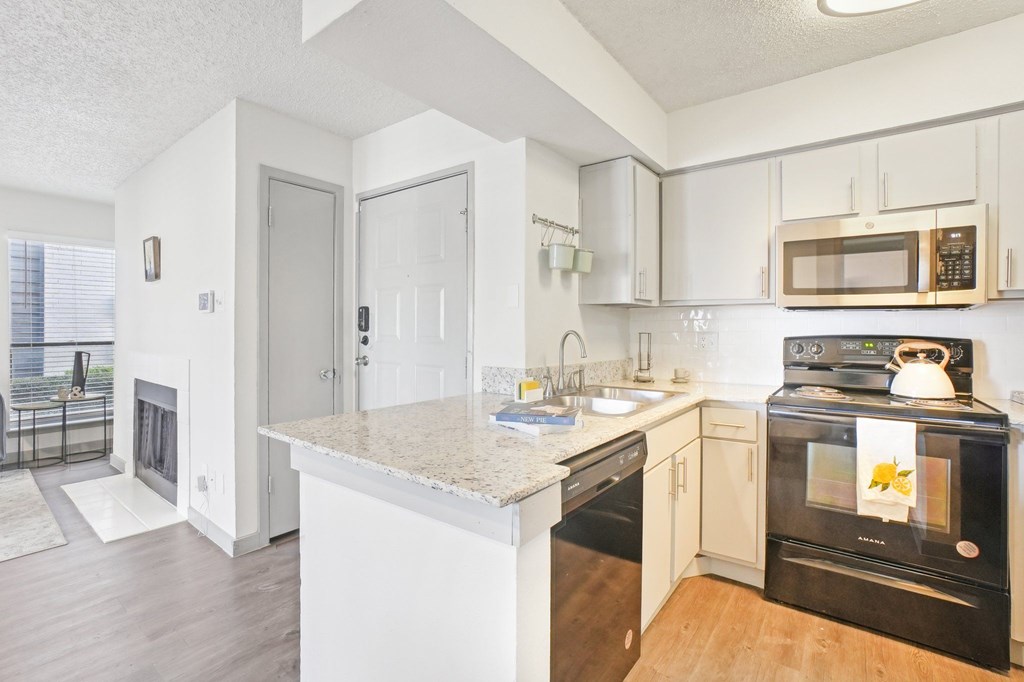 A kitchen with a stove top oven and a microwave above the stove.