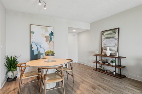 A dining room with a round table and chairs.