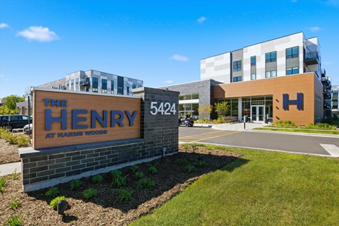The Henry Apartments at Harlan Woods building with a sign in front.