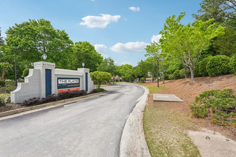 The Flats residential complex is surrounded by greenery and has a clear blue sky above.