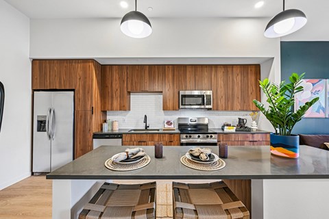 A modern kitchen with wooden cabinets and a central island.
