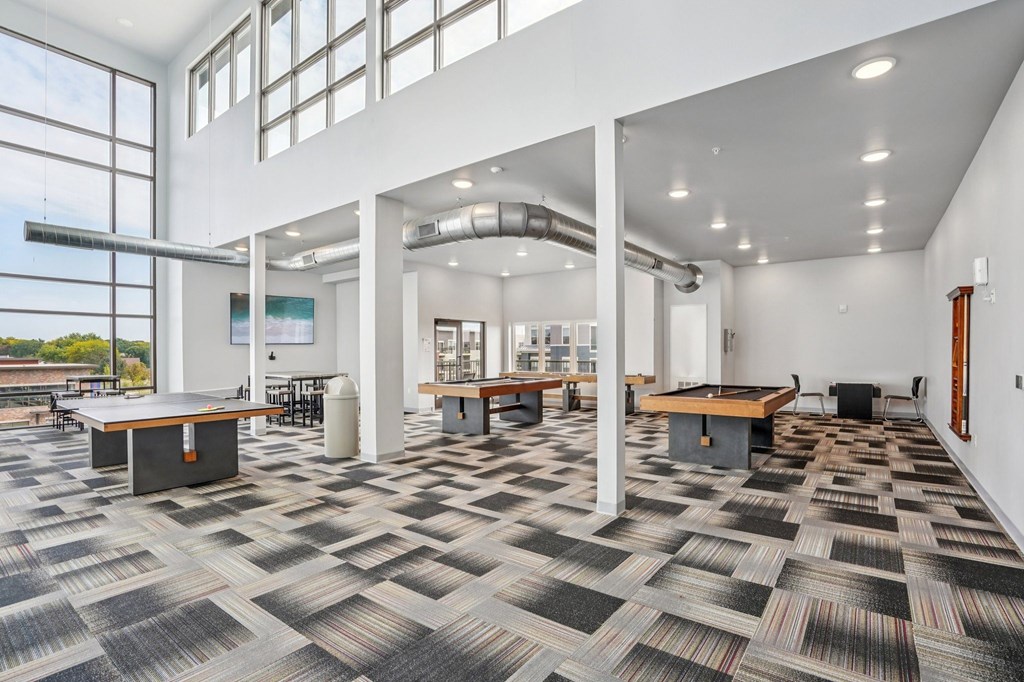 A large open room with a carpeted floor and a long table.