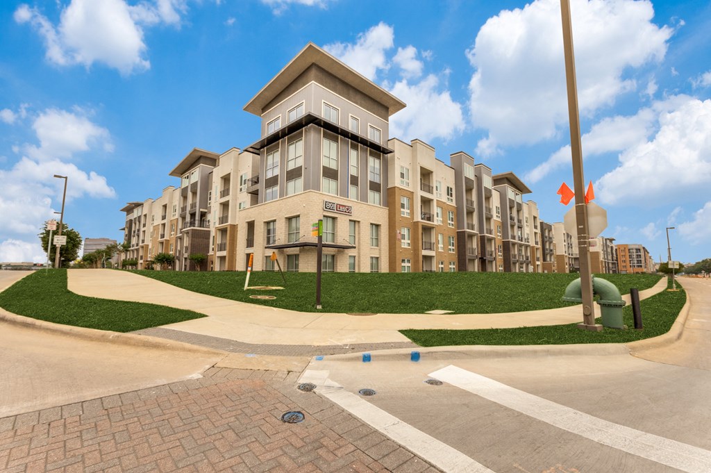 an exterior view of an apartment building with a playground in front of it