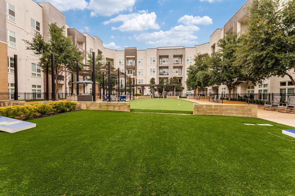 a large green lawn in front of an apartment complex