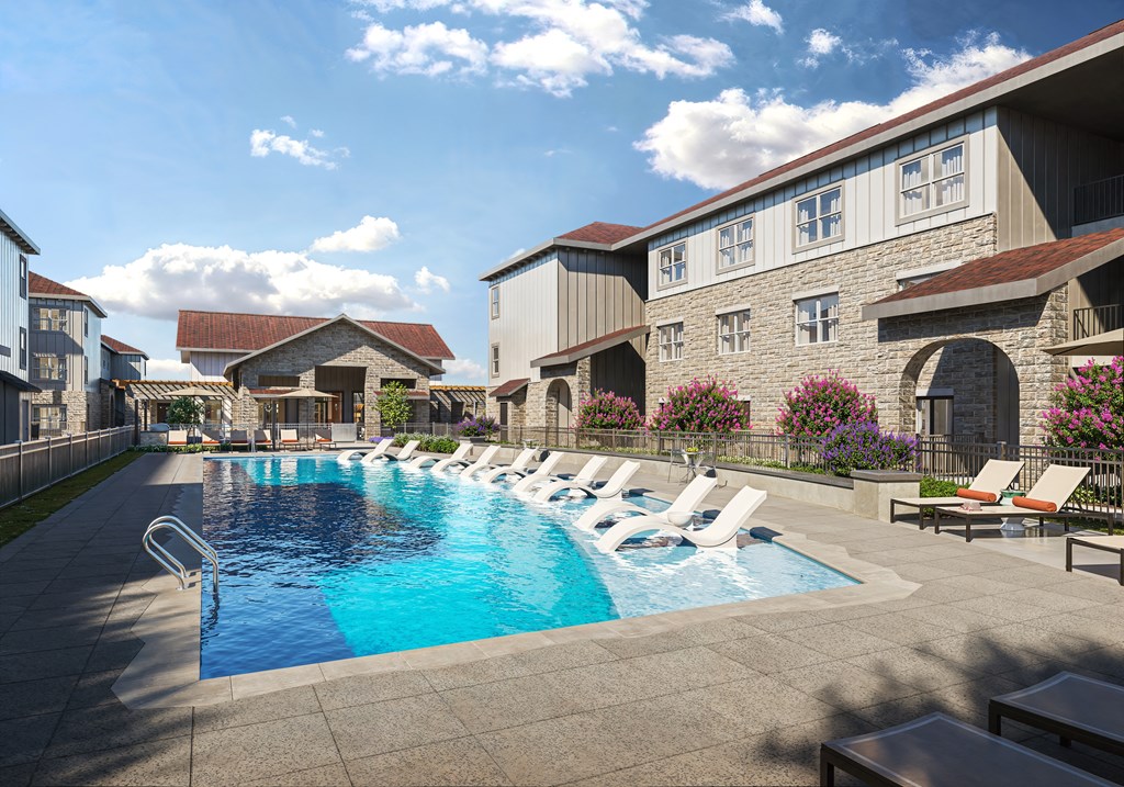 A swimming pool surrounded by lounge chairs and buildings.
