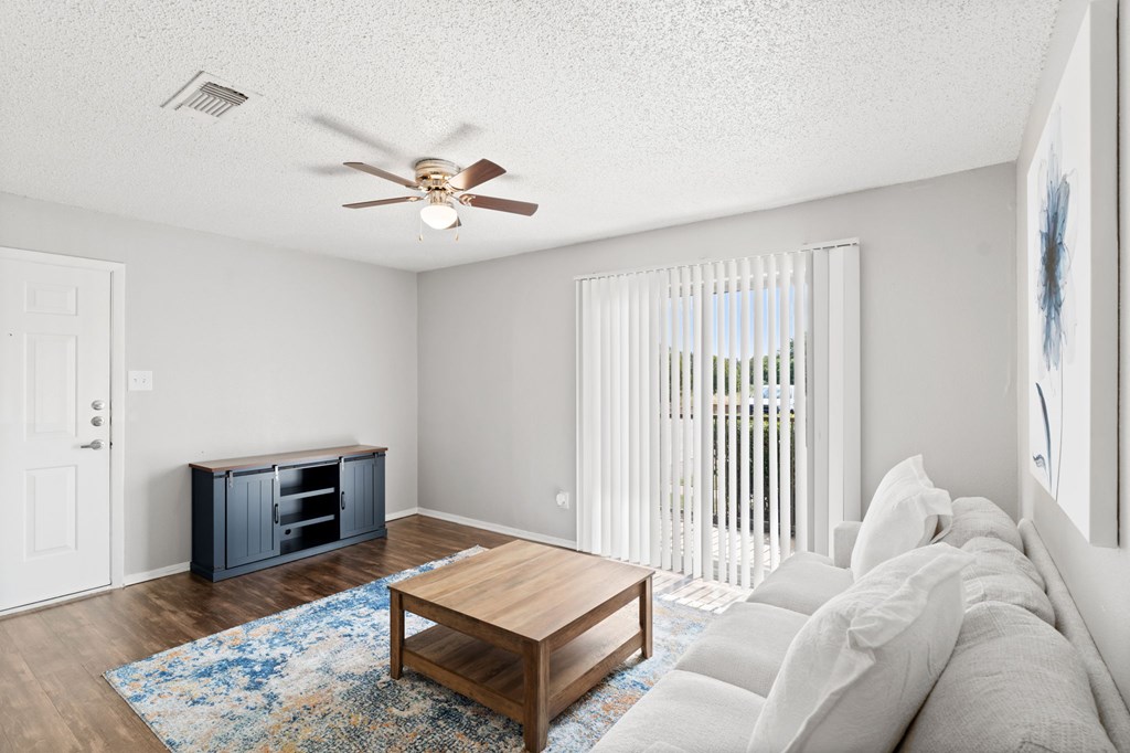 A living room with a wooden coffee table and a white couch.