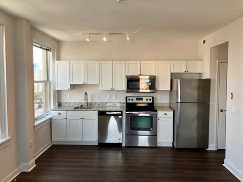 A kitchen with white cabinets and stainless steel appliances.