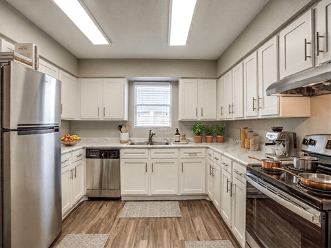 A kitchen with white cabinets and stainless steel appliances.