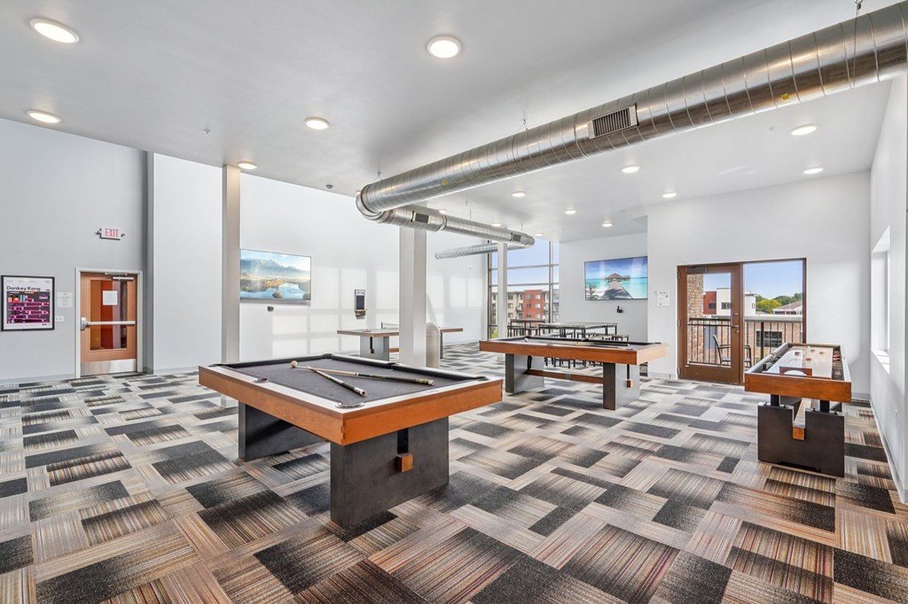 A room with a pool table and a bench.