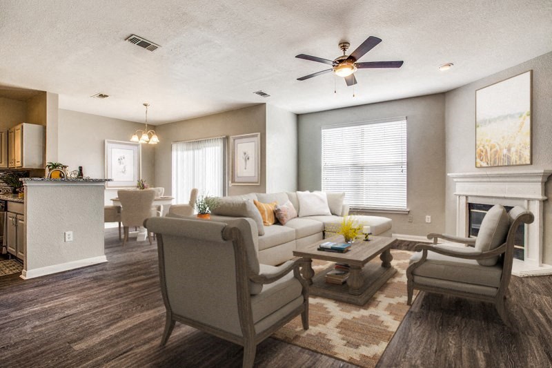 a living room with a couch and chairs and a ceiling fan