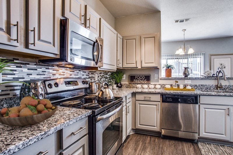 a kitchen with stainless steel appliances and marble counter tops