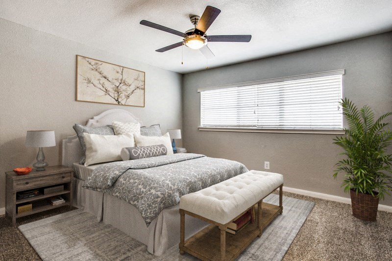 a bedroom with a bed and a ceiling fan