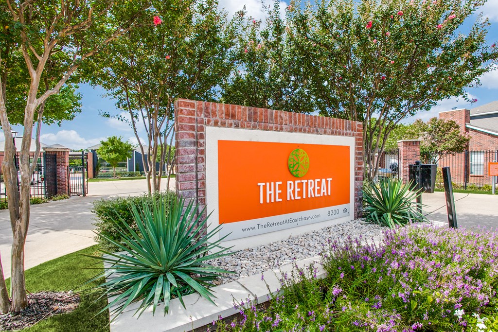 the retreat at thousand oaks apartments sign in front of trees and plants