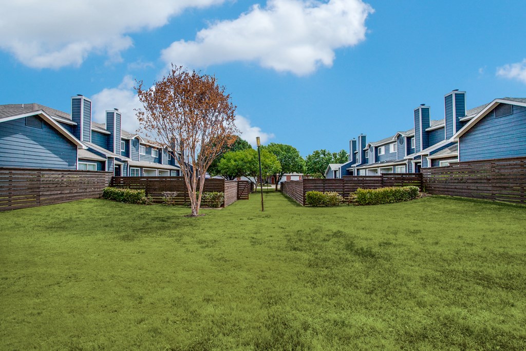 a green lawn in front of a row of houses