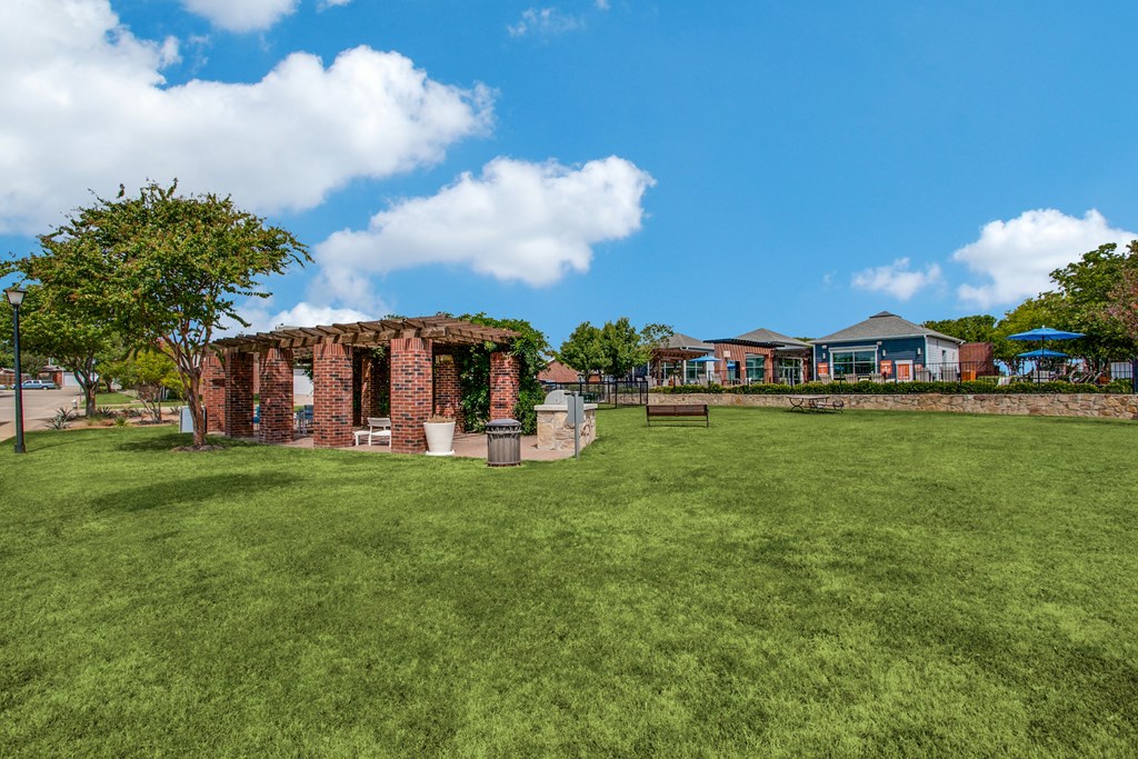 a brick building sits in the middle of a grassy field