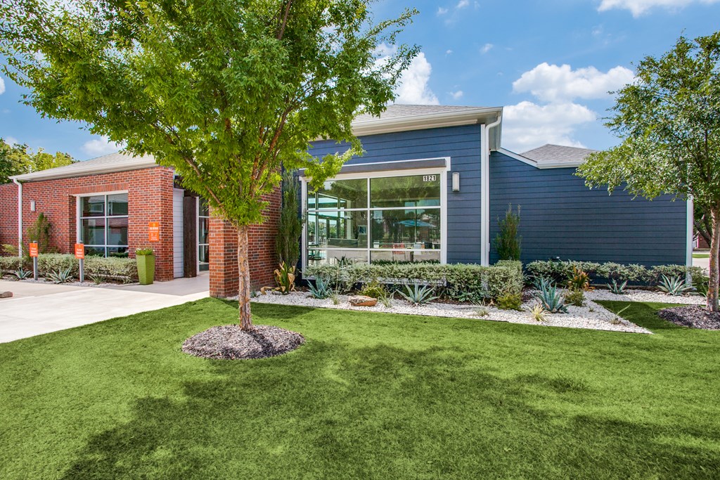 the front of a house with a yard and a tree