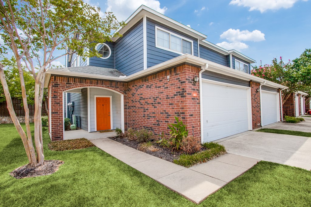 a blue house with a red door and a sidewalk