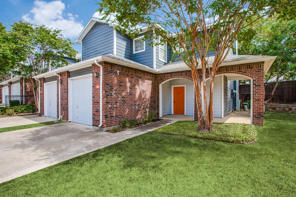 a blue and brick house with a tree in the front