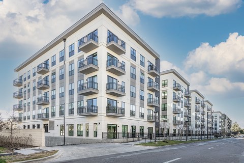 a large apartment building with balconies and a street in front of it
