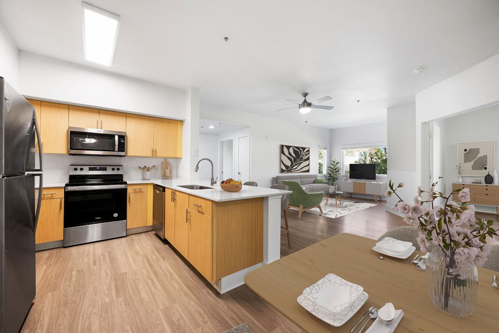 a kitchen and living room with wooden floors and a table