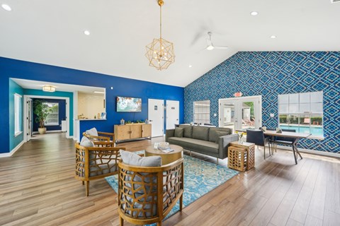 A living room with a blue wallpaper and wooden furniture.