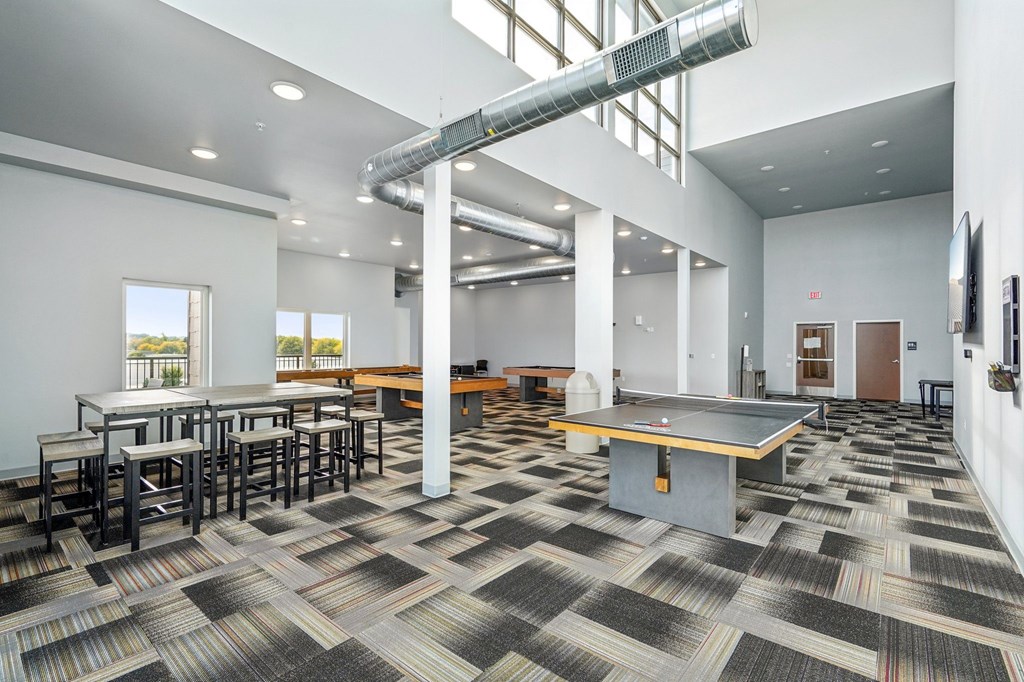 A room with a long table and a ping pong table.