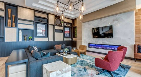 A modern living room with a grey sofa, a red chair, and a TV mounted on the wall.