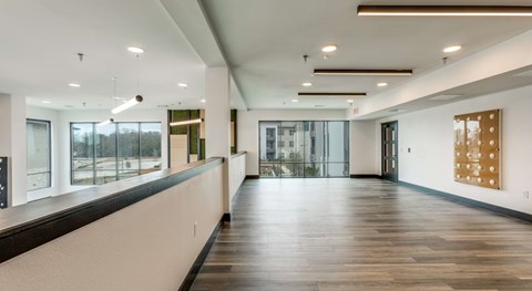 A long hallway with wood floors and white walls.