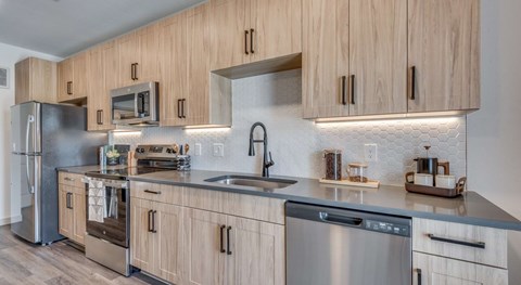 A modern kitchen with wooden cabinets and stainless steel appliances.