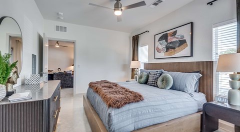 A bedroom with a large bed and a ceiling fan.