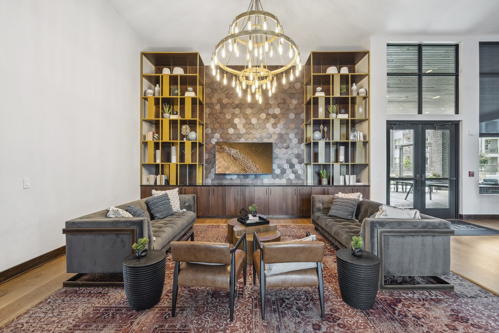 a living room with couches and a fireplace and a chandelier
