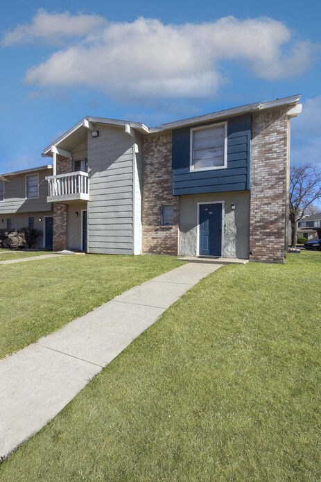 a blue and white house with a sidewalk in front of it