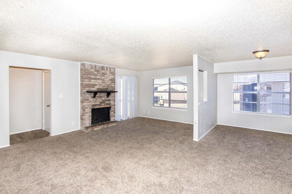 an empty living room with a fireplace